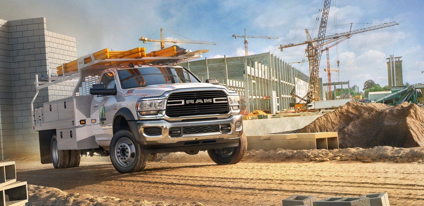 The 2022 Ram 5500 SLT Chassis Cab, upfitted with side storage boxes and an overhead storage rack.