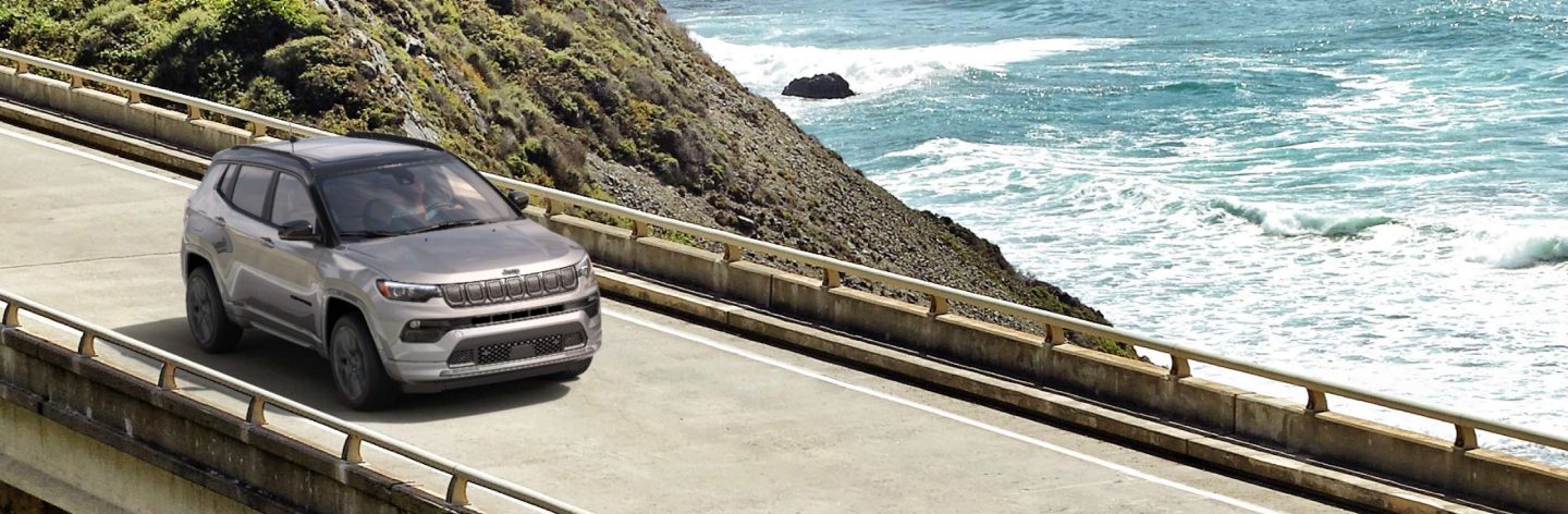 The 2022 Jeep Compass High Altitude being driven on a bridge over water.