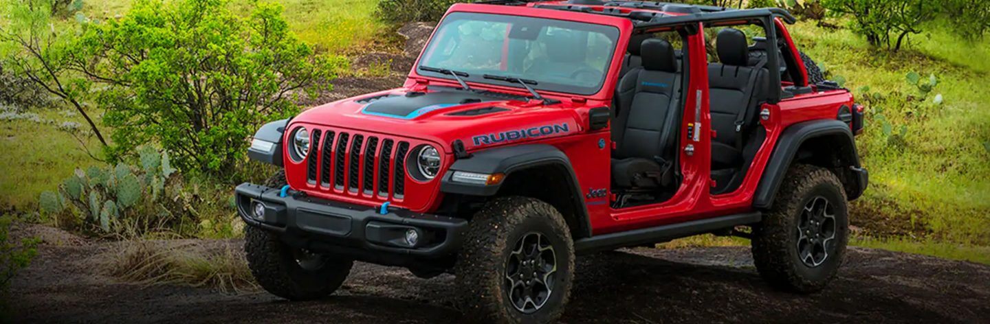 The 2023 Jeep Wrangler Rubicon 4xe parked off-road with its top and doors off.