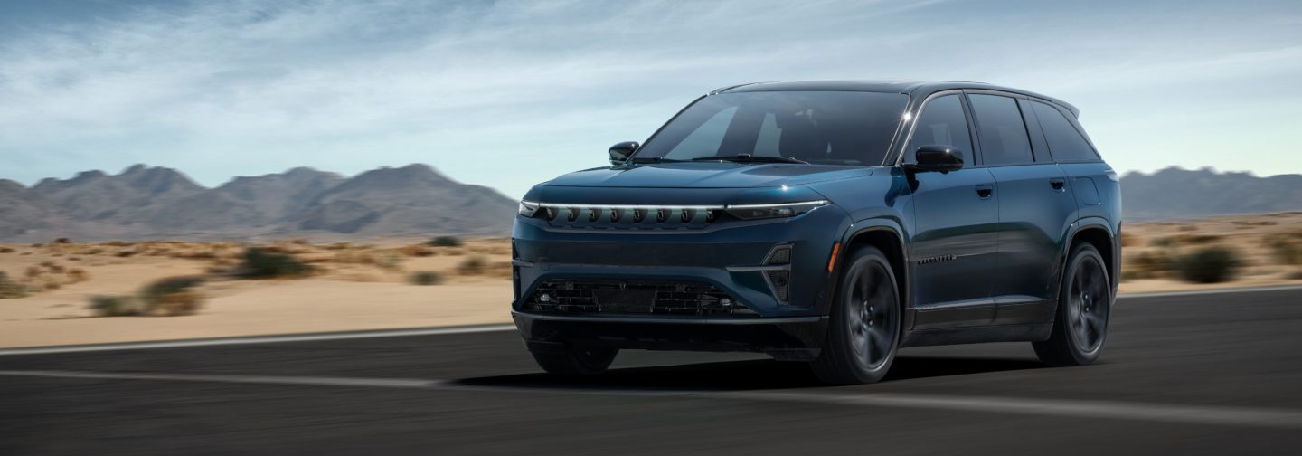 A blue 2024 Jeep Wagoneer S Launch Edition being driven on a highway in the desert.