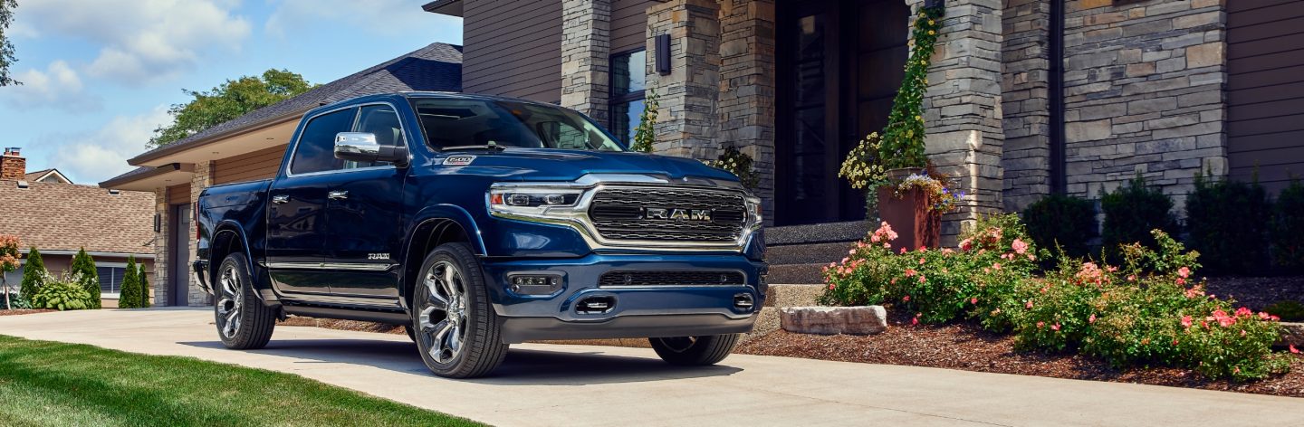 The 2023 Ram 1500 parked in the driveway of a nicely landscaped home.